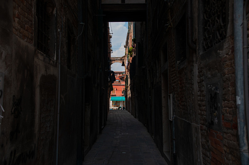 A dark alley in the city of Venice during a hot day in the summer