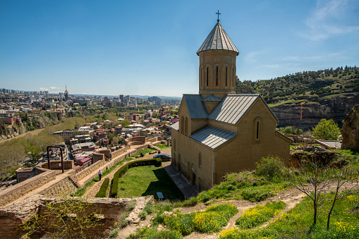 Amazing panorama  with hurch st. Nicholas in the 4th century Narikala Fortress and part of the Kura River in Tbilisi and the spire of the National Georgian University in the distance. Blurred motion people.