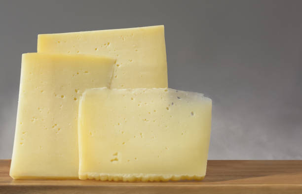 istock Three pieces of hard cheese on a gray background 1464558371