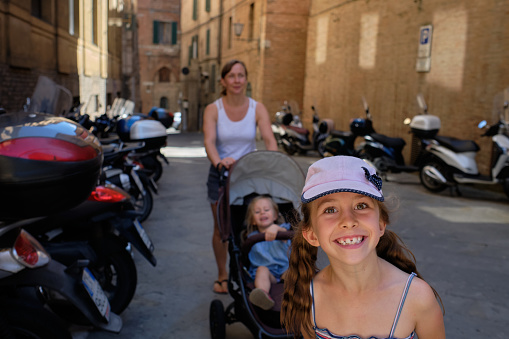 Family sightseeing trip in Florence, young family is walking down the street of Florence old town