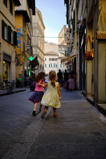 Family sightseeing trip in Florence, small sisters are having fun while exploring historical center of Florence