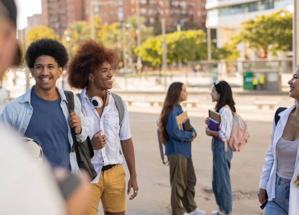 istock happy international students talk while leaving class, focus on african american man 1464568124