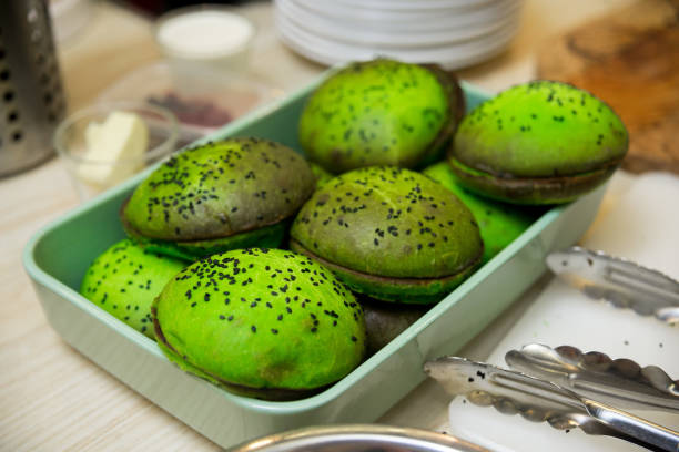 Green dough buns with black sesame seeds on wooden table stock photo