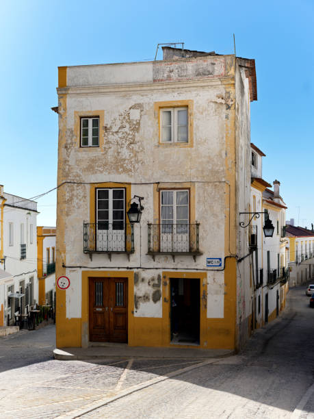 A house on the corner of a street with no people and blue sky