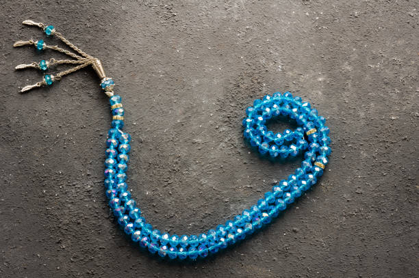 istock Arabic letter wav made with blue rosary on gray rustic background, islamic symbol 1464577273