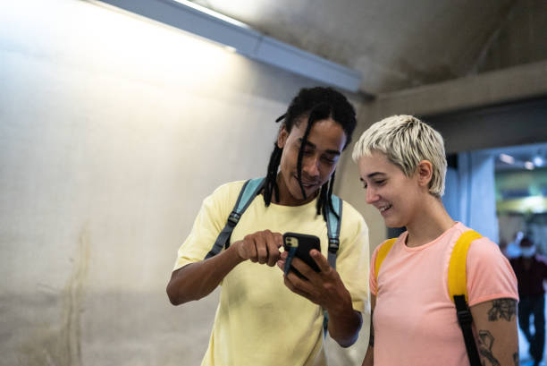 istock Friends using the mobile phone while walking in the subway station 1464578464