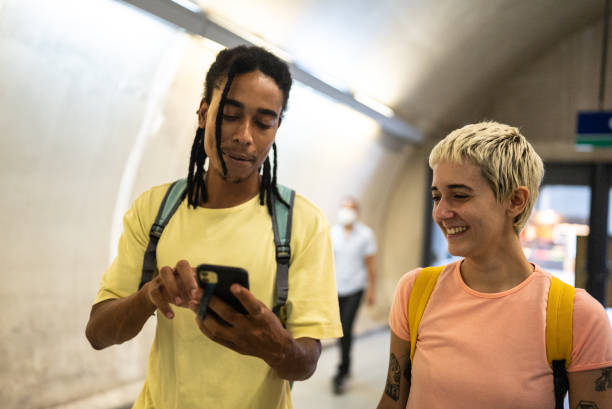 istock Friends using the mobile phone while walking in the subway station 1464578522