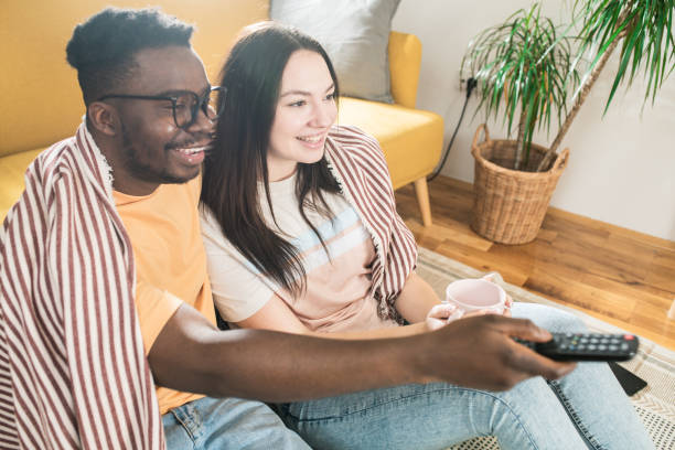 istock Happy couple watching TV at home 1464578974