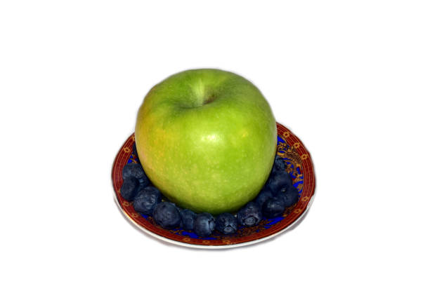An apple on a small plate isolated on a white background