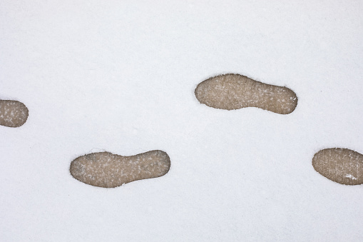 Winter embrased footpath with footsteps in snow from animals