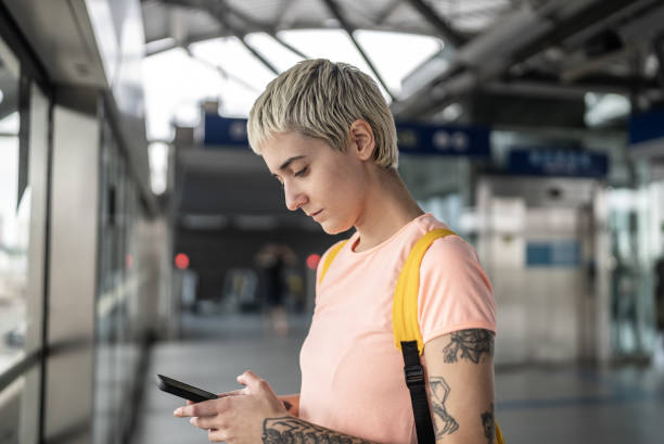 istock Young woman using the mobile phone in the subway station 1464581126