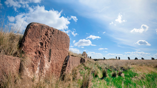 The ruins of an ancient sanctuary with the remains of walls and menhirs lying in the steppe tied with ritual ribbons. Big Salbyk Kurgan, Khakassia, South Siberia, Russia.
