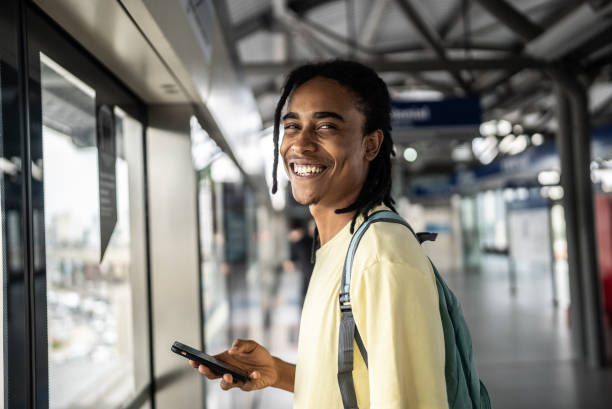 Portrait of a young man using the mobile phone in the subway station Portrait of a young man using the mobile phone in the subway station standing on subway platform stock pictures, royalty-free photos & images