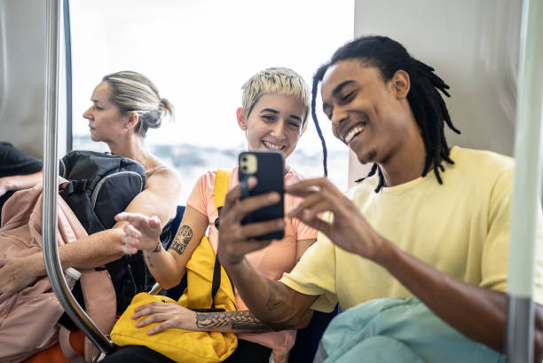 istock Friends using the mobile phone in the train 1464581793