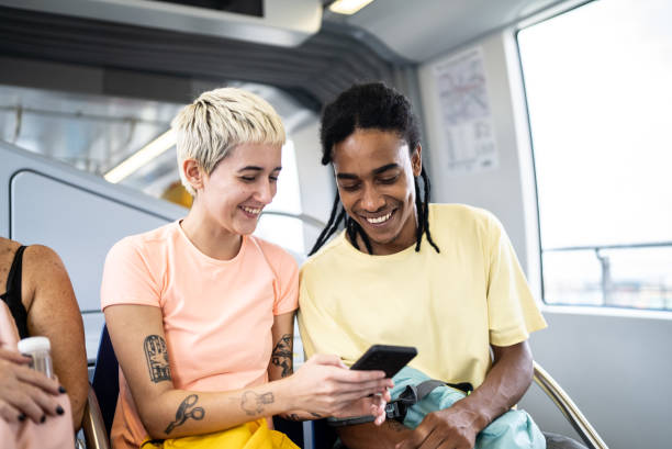 Friends using the mobile phone and talking in the train