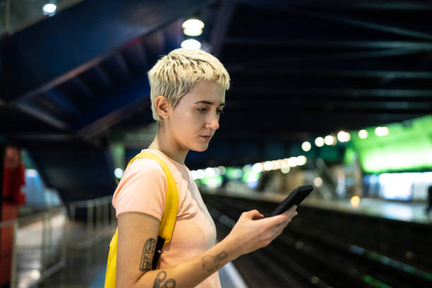 istock Young woman using the mobile phone in the subway station 1464583130