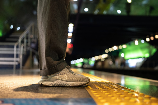 Person's legs waiting for the train in the subway station