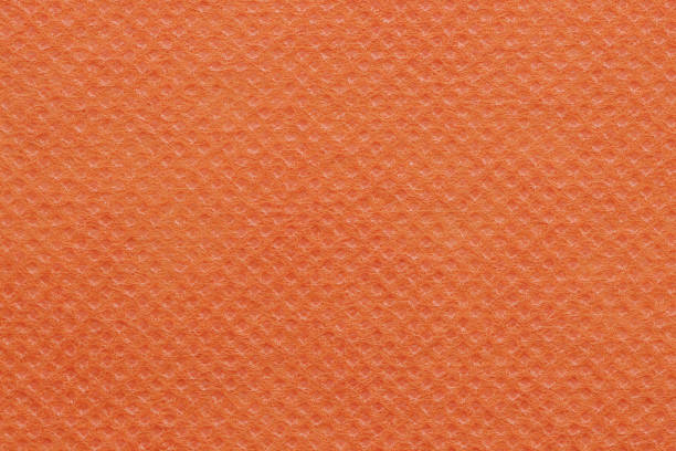 Orange non-woven polypropylene fabric texture. A piece of eco-friendly shopping bag material.