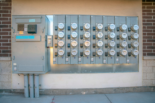 Multi-family electrical box and smart meters outdoors at Phoenix, Arizona. Electric meters near the wall of a building with bricks.