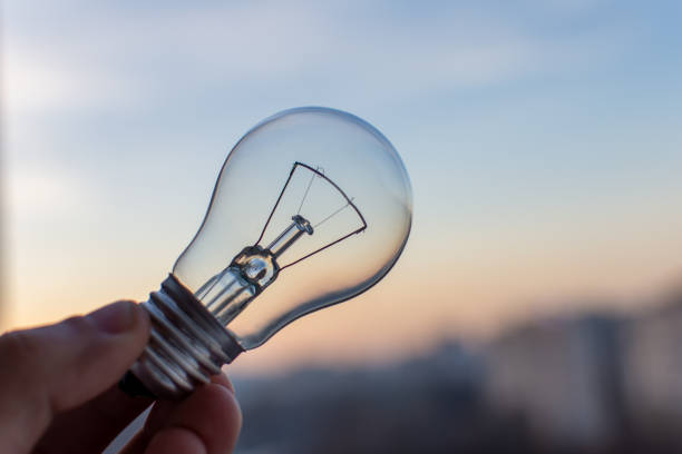 istock Incandescent lamp on sunset background 1464590383