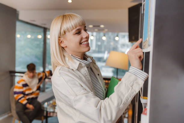 istock Smiling young woman in the library 1464593338