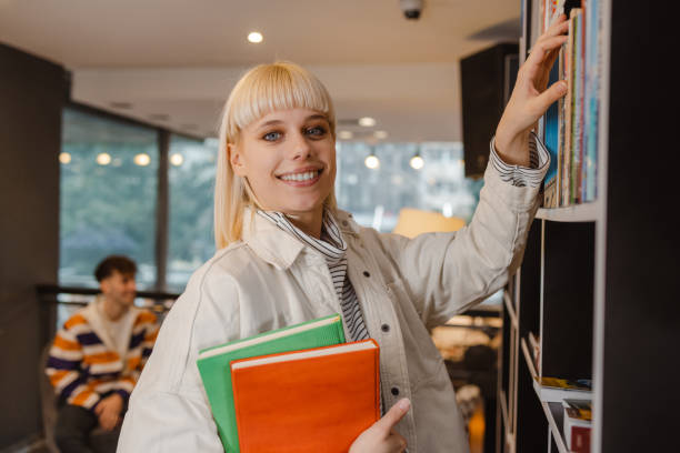 istock Smiling young woman in the library 1464593354