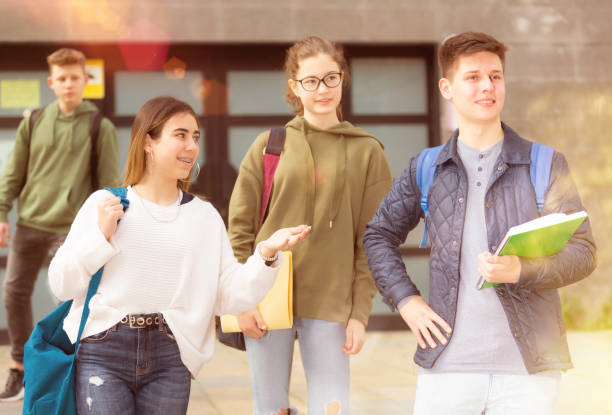 istock Smiling teenagers walking outside after lessons 1464593484