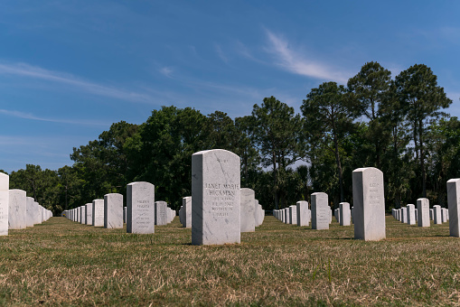 PENSACOLA, FLORIDA - CIRCA JUNE, 2022: Headstones at Barrancas National Cemetery at Cemetery Road. White marble headstones with names of the deceased.
