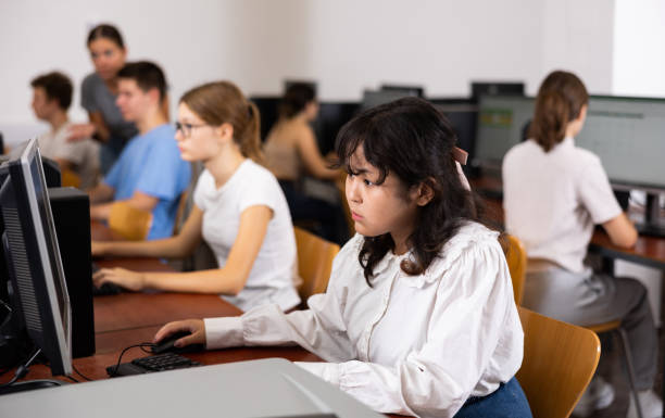 Focused Asian female teenager solving tasks of computer science in the auditory