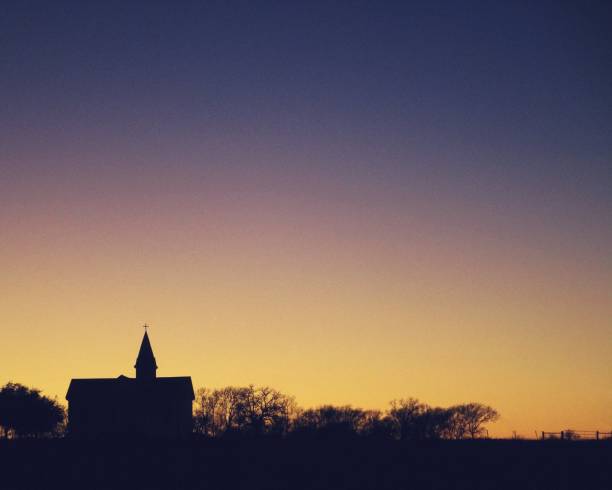 Silhouetted Church on Rural Horizon at Twilight A rural church steeple, silhouetted against a winter twilight sky along a horizon in central Texas. religious institutions stock pictures, royalty-free photos & images