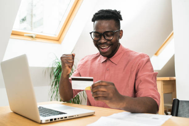 istock Young man shopping online at home 1464599601