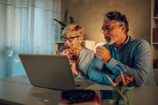 自宅でラップトップを使用してシニ�アカップル - senior adult couple computer retirement ストックフォトと画像