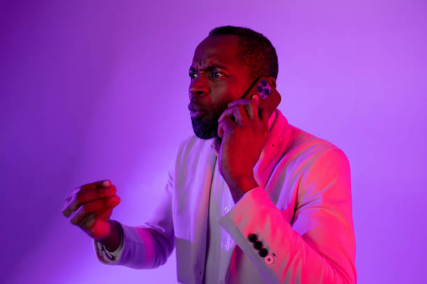 istock businessman talking on smartphone, man making phone call. a man waves his hands while talking on the phone 1464602234