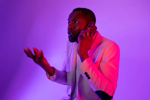istock businessman talking on smartphone, man making phone call. a man waves his hands while talking on the phone 1464602236