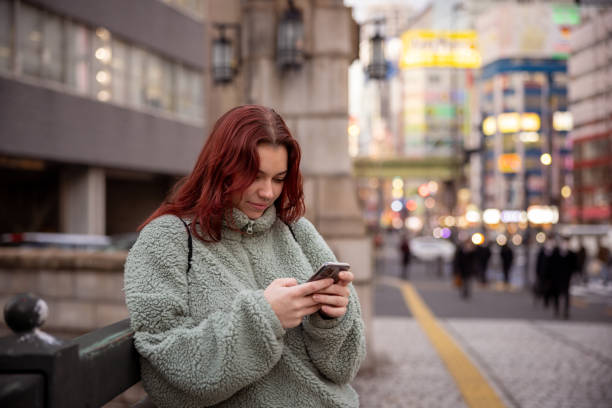 istock Young female tourist using smart phone on bridge 1464604439