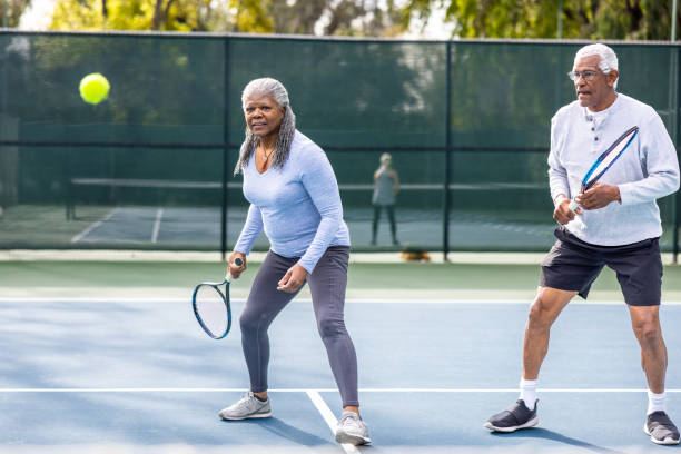 istock Senior Black Couple Playing Doubles Tennis 1464605216