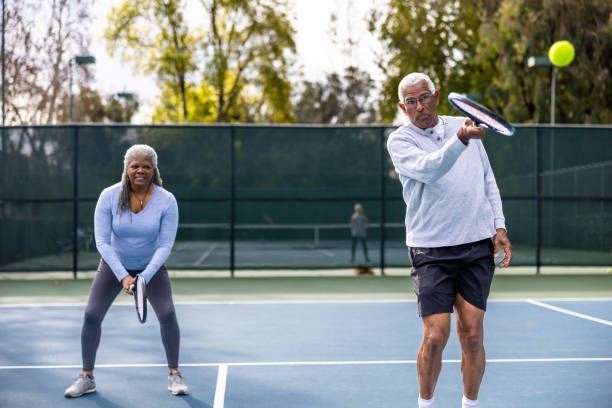 istock Senior Black Couple Playing Doubles Tennis 1464605343