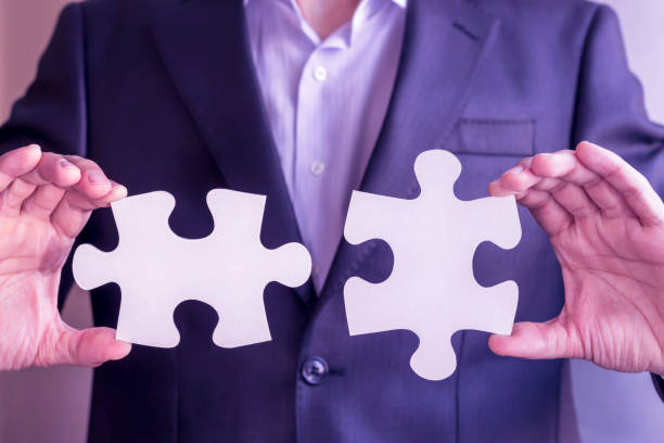 istock businessman in suit holding white puzzle pieces. Concept: diversity, team work, racism, and access solution. 1464607432