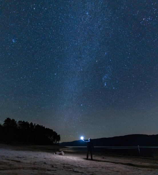 istock Man at night stargazing. Getting away from it all. 1464608305