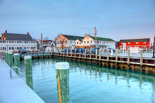 Huntington, NY USA - Aug 19, 2022: Boats in Huntington Harbor on a summer day. In the foreground is Halesite Park. Trees fill the west shore behind the boats in this narrow bay.