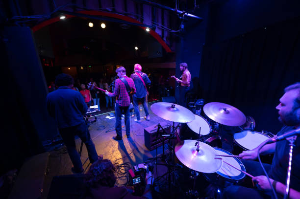 istock Rock Band Performing Onstage with Videographer Recording Them 1464613369