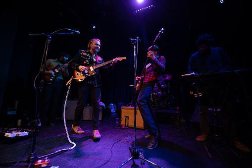 An Americana folk-rock band performing onstage in front of an audience at a live music venue.