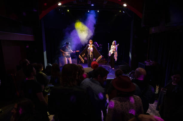istock Singer Wearing Cape Performing On Stage with Band 1464613410