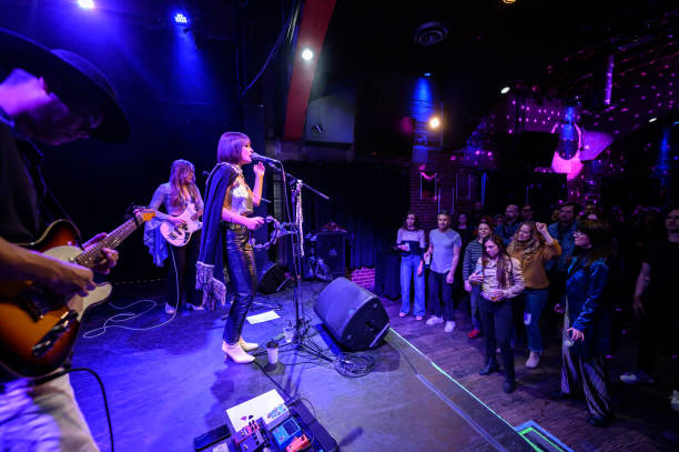 istock Audience Dancing to Live Band Performing On Stage at Small Venue 1464613422