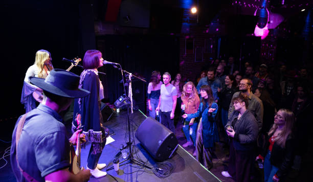 istock Packed Crowd at Small Venue Watching Band Perform On Stage 1464613429