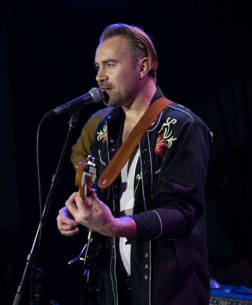 istock Man Playing Guitar and Singing On Stage 1464613556