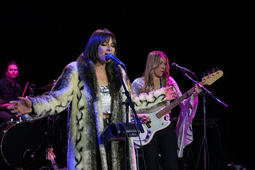 A woman singing with a band on stage.