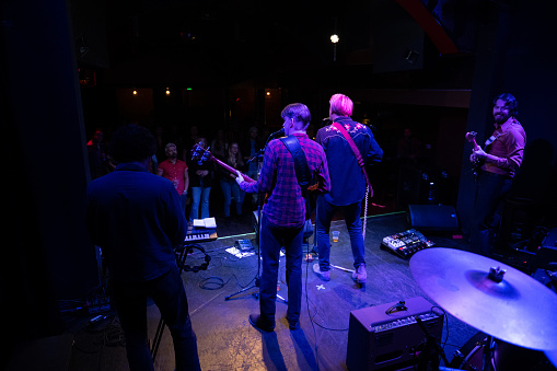 An Americana folk-rock band performing onstage in front of an audience at a live music venue.