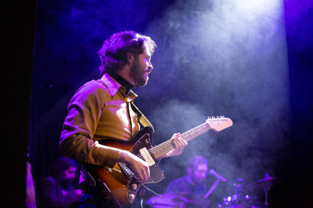 istock Guitarist Playing Onstage Under Spotlight 1464613738