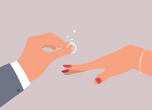 Female’s Hand Accepting Marriage Proposal With Male’s Hand In Businesswear Holding A Big Shiny Diamond Ring. Isolated On Color Background.